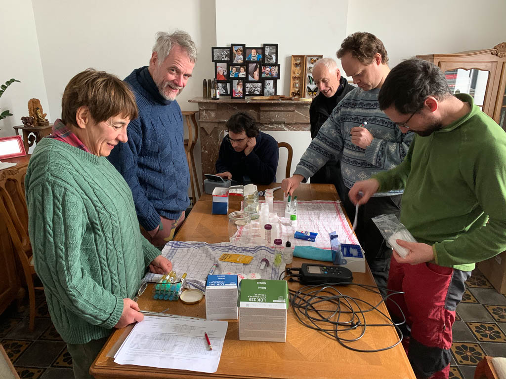 Volontaires en train d'analyser des échantillons d'eau, autour d'une table